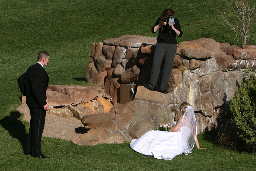 photographer shooting bride at a wedding to show her in action with customers--an effective way to use images to market her business