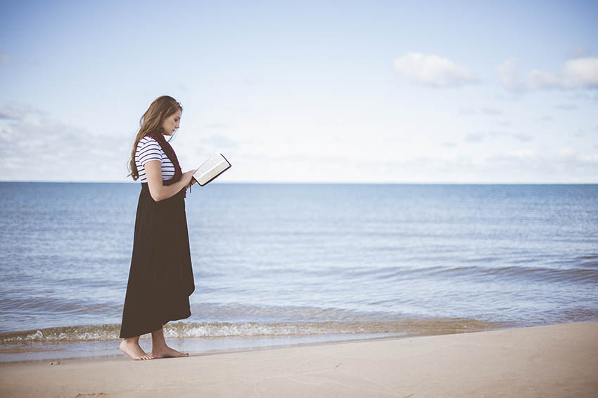 woman reading a book at the beach