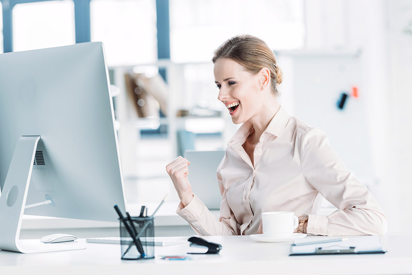 woman at computer celebrating her success