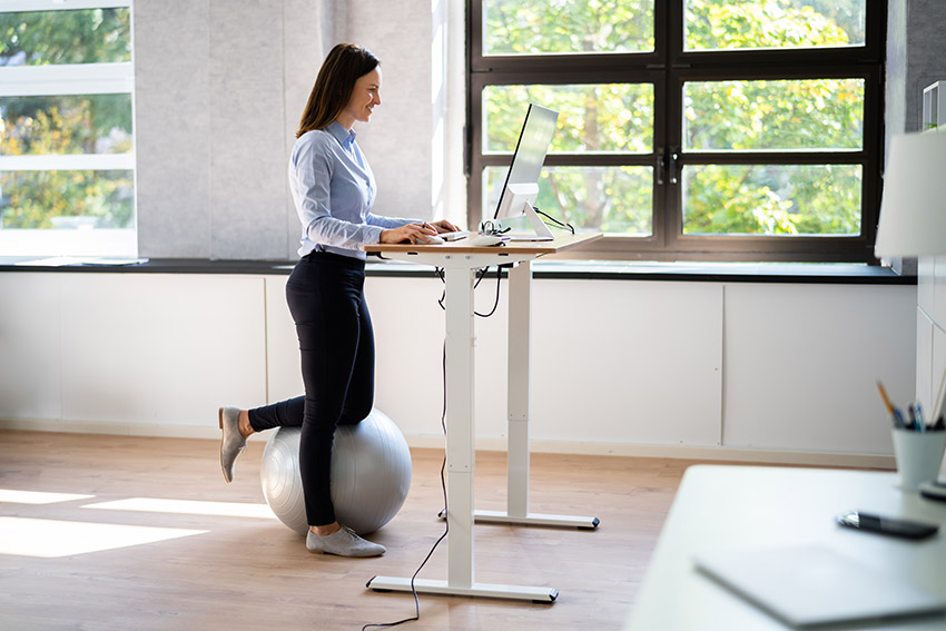 woman working at a standing desk to make her home office more inviting